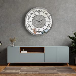 Round silver patina mirrored wall clock hanging in silver room.
