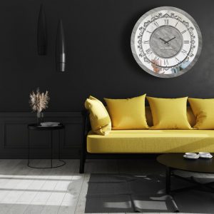 Round silver patina mirrored wall clock hanging in black room.