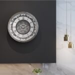 Introducing our stunning Roman Numeral Wall Clock, the perfect addition to your living room decor! This unique wall art piece features a chic vintage look with a round design in a beautiful silver patina finish. Elegant and timeless, this clock will make a statement in any room it's placed in. Elevate your space with this exquisite piece that combines functionality with style. Perfect for adding a touch of sophistication to your home, this Roman Numeral Wall Clock is sure to impress your guests and become a focal point in your space. Make a stylish statement with this elegant wall clock today!