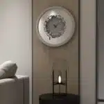Add a touch of elegance to your space with this traditional round-shaped handmade wall clock adorned with 5 stunning surrounding colors - black, gray, gold, beige, and walnut. The captivating design feature of this piece is the intricate Persian calligraphy encircling the mirrored clock, creating a stylish one-of-a-kind look that shines beautifully on any wall. This large modern wall clock is not only a functional timepiece but also a stunning piece of art. With its oversized silhouette and silent mechanism, it is perfect for adding a bold statement to your kitchen or any room in your home. Make a stylish statement with this unique and eye-catching timepiece.