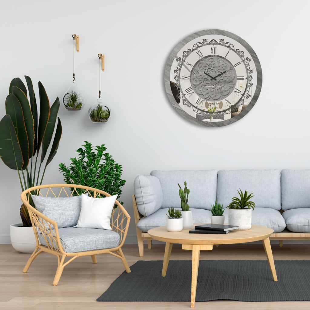Round silver patina mirrored wall clock hanging in white living room.