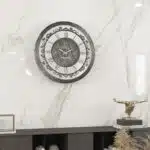 Introducing our stunning Roman Numeral Wall Clock, the perfect addition to your living room decor! This unique wall art piece features a chic vintage look with a round design in a beautiful silver patina finish. Elegant and timeless, this clock will make a statement in any room it's placed in. Elevate your space with this exquisite piece that combines functionality with style. Perfect for adding a touch of sophistication to your home, this Roman Numeral Wall Clock is sure to impress your guests and become a focal point in your space. Make a stylish statement with this elegant wall clock today!