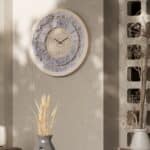 Handmade round Roman numeral wall clock with beige wooden frame and patina floral mirror design