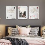 Three rectangle mosaic mirrors designed as playing cards hung in grey bedroom above bed.