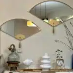 Add a touch of modern elegance to your living room décor with this unique asymmetrical mirror. Perfect for adding a contemporary flair to any space, this irregular fan-shaped mirror is both stylish and functional. Whether it's hanging in the bathroom as a vanity mirror or displayed in the living room as a statement piece, this mirror is sure to impress. Available in both large and small sizes, it also makes a thoughtful housewarming gift for your loved ones. Upgrade your home with this modern and minimalistic mirror today!