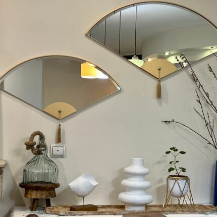 Add a touch of modern elegance to your living room décor with this unique asymmetrical mirror. Perfect for adding a contemporary flair to any space, this irregular fan-shaped mirror is both stylish and functional. Whether it's hanging in the bathroom as a vanity mirror or displayed in the living room as a statement piece, this mirror is sure to impress. Available in both large and small sizes, it also makes a thoughtful housewarming gift for your loved ones. Upgrade your home with this modern and minimalistic mirror today!