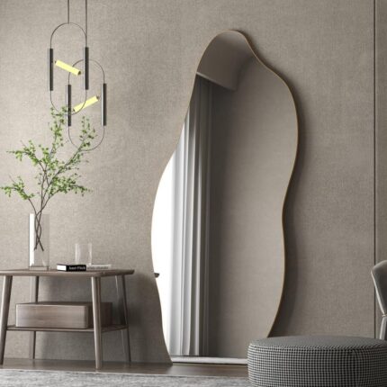 Asymmetrical floor mirror with an irregular shape leaning against a wall, providing a full-length reflection.