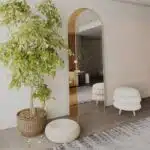 Add a touch of contemporary elegance to your living space with this Modern Arched Floor Mirror. This full-length lean wall mirror features an asymmetrical design, perfect for adding a chic flair to your housewarming decor. Use it as a leaner mirror in your bedroom or living room to create the illusion of a larger space while adding a stylish statement piece. Elevate your home decor with this stunning and sleek large mirror that will instantly upgrade any room in your house.