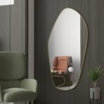 Add a touch of elegance to your space with this stunning Asymmetrical Vanity Mirror. Featuring an irregular design, this entryway mirror is both unique and eye-catching. The gold finish adds a touch of luxury, making it a perfect addition to your bathroom or as a statement piece in your living room. This large mirror wall décor is not only functional but also adds depth and style to any room. Use it as a full-length mirror to check your outfit before heading out or simply as a beautiful decor piece to enhance your home.