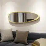 Elevate your space with this stunning Mid Century Asymmetrical Black Mirror. This Irregular Bathroom Vanity Mirror is the perfect addition to any stylish Living Room Décor. The large size makes it ideal as a statement piece or as a practical Housewarming Gift for her. Add a touch of sophistication to your home with this unique and modern wall mirror.