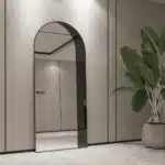 Add a touch of contemporary elegance to your living space with this Modern Arched Floor Mirror. This full-length lean wall mirror features an asymmetrical design, perfect for adding a chic flair to your housewarming decor. Use it as a leaner mirror in your bedroom or living room to create the illusion of a larger space while adding a stylish statement piece. Elevate your home decor with this stunning and sleek large mirror that will instantly upgrade any room in your house.