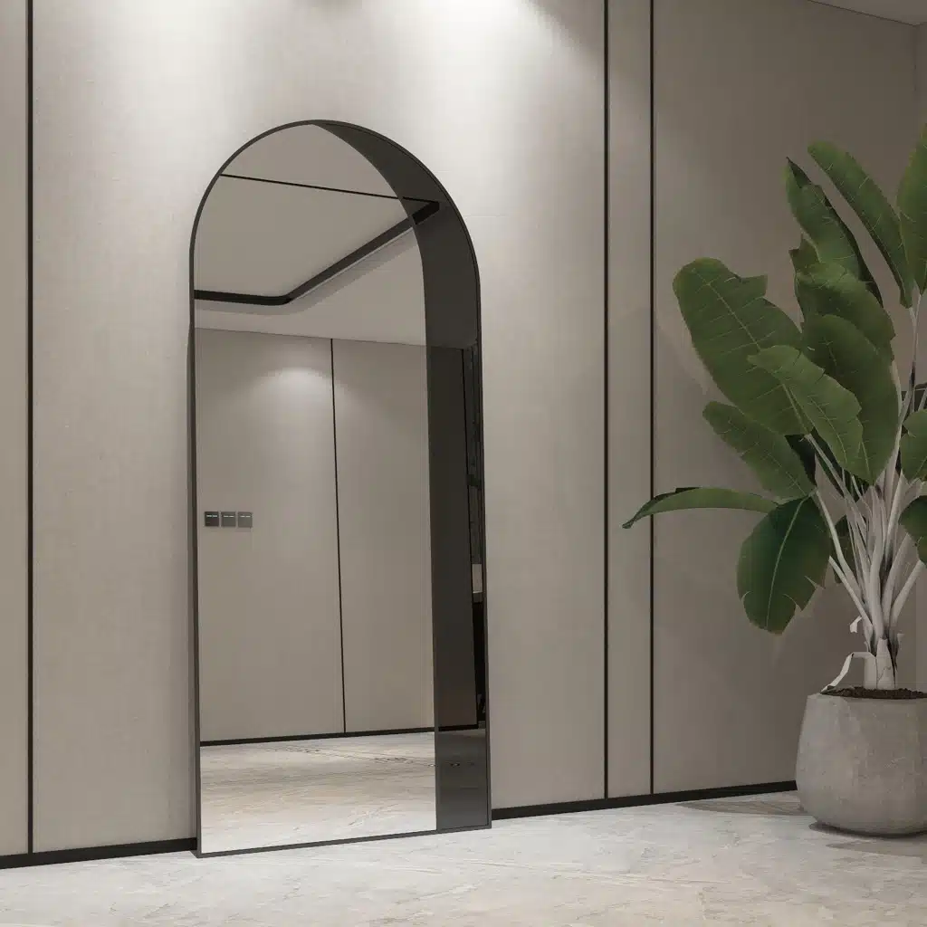 Add a touch of contemporary elegance to your living space with this Modern Arched Floor Mirror. This full-length lean wall mirror features an asymmetrical design, perfect for adding a chic flair to your housewarming decor. Use it as a leaner mirror in your bedroom or living room to create the illusion of a larger space while adding a stylish statement piece. Elevate your home decor with this stunning and sleek large mirror that will instantly upgrade any room in your house.