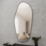 Add a touch of modern elegance to your space with this stunning ASYMMETRICAL VANITY MIRROR. This unique piece features an Irregular Mirror design that is perfect for adding a stylish flair to your Entryway or Bathroom. The Gold Wall Mirror adds a glamorous touch, while the Large Mirror size makes it perfect for wall décor or as a Full length Mirror. Elevate your home decor with this chic and versatile piece that is sure to make a statement in any room.