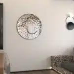 Add a touch of modern elegance to your living room or bathroom with this stunning Round Asymmetrical Mirror. This unique accent decor piece features a large circle wall mirror with a decorative sunburst style, making it the perfect statement piece for any space. Whether used as a bathroom vanity mirror or as a focal point in your living room, this mirror is sure to elevate your decor with its sleek and stylish design. Make a bold statement with this eye-catching mirror that seamlessly blends style and function.