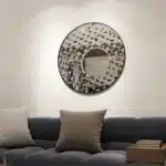 Add a touch of modern elegance to your living room or bathroom with this stunning Round Asymmetrical Mirror. This unique accent decor piece features a large circle wall mirror with a decorative sunburst style, making it the perfect statement piece for any space. Whether used as a bathroom vanity mirror or as a focal point in your living room, this mirror is sure to elevate your decor with its sleek and stylish design. Make a bold statement with this eye-catching mirror that seamlessly blends style and function.