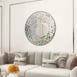 Add a touch of elegance and style to your space with this Round Asymmetrical Mirror. Perfect for your living room decor or as a statement piece in your bathroom, this large circle wall mirror will bring a unique accent to any room. The decorative sunburst style adds a modern flair while also incorporating a classic design. Elevate your home decor with this stunning mirror that will surely catch the eye of all your guests.