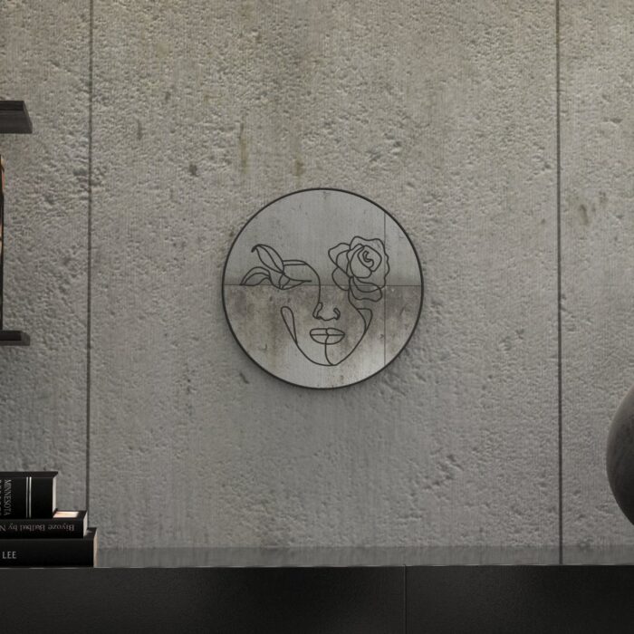 "Etched line drawing of a woman's face intertwined with a mix of flowers on a round wall mirror, showcasing intricate and artistic design."