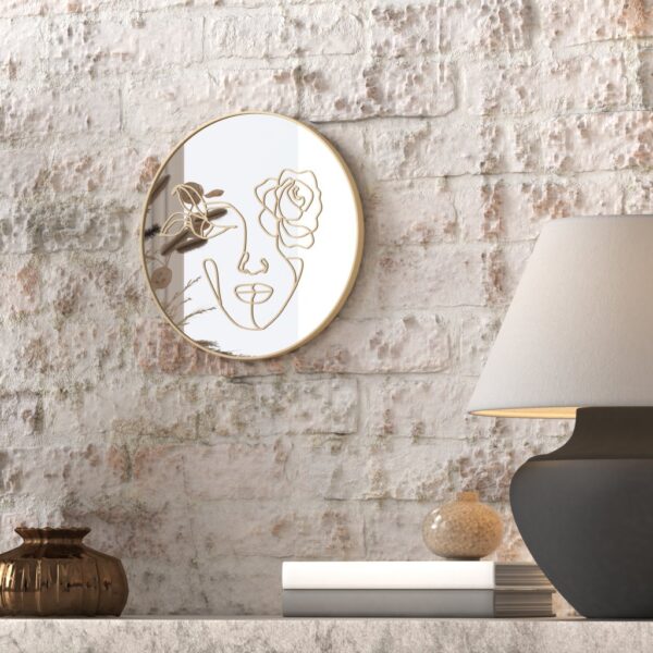 "Etched line drawing of a woman's face intertwined with a mix of flowers on a round wall mirror, showcasing intricate and artistic design."