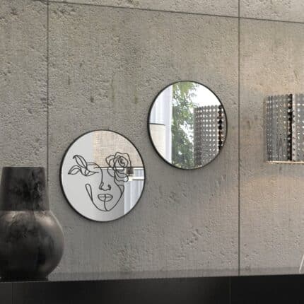 "Etched line drawing of a woman's face intertwined with a mix of flowers on a round wall mirror, showcasing intricate and artistic design."