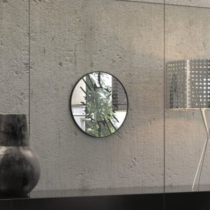 Small round wall mirror with an etched Persian calligraphy design featuring the words 'Women, Life, Freedom,' framed in a gold and black color scheme, hanging on a wall.