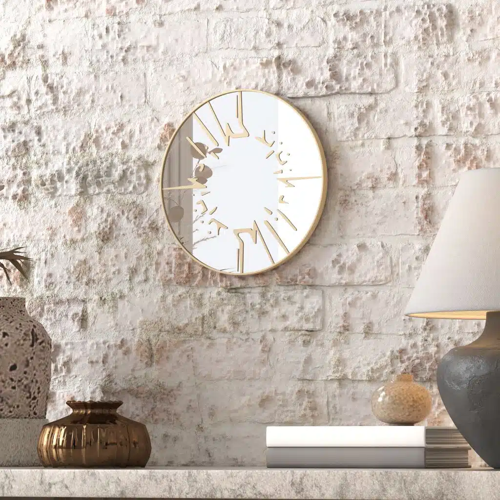 Small round wall mirror with an etched Persian calligraphy design featuring the words 'Women, Life, Freedom,' framed in a gold and black color scheme, hanging on a wall.