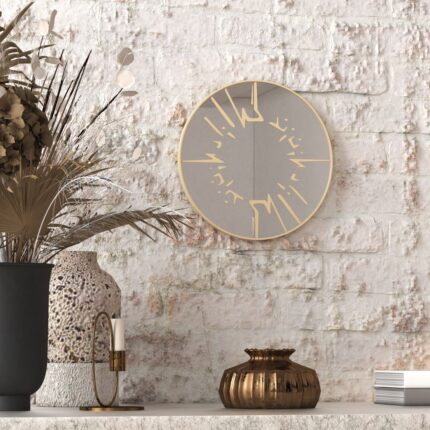 Small round wall mirror with an etched Persian calligraphy design featuring the words 'Women, Life, Freedom,' framed in a gold and black color scheme, hanging on a wall.