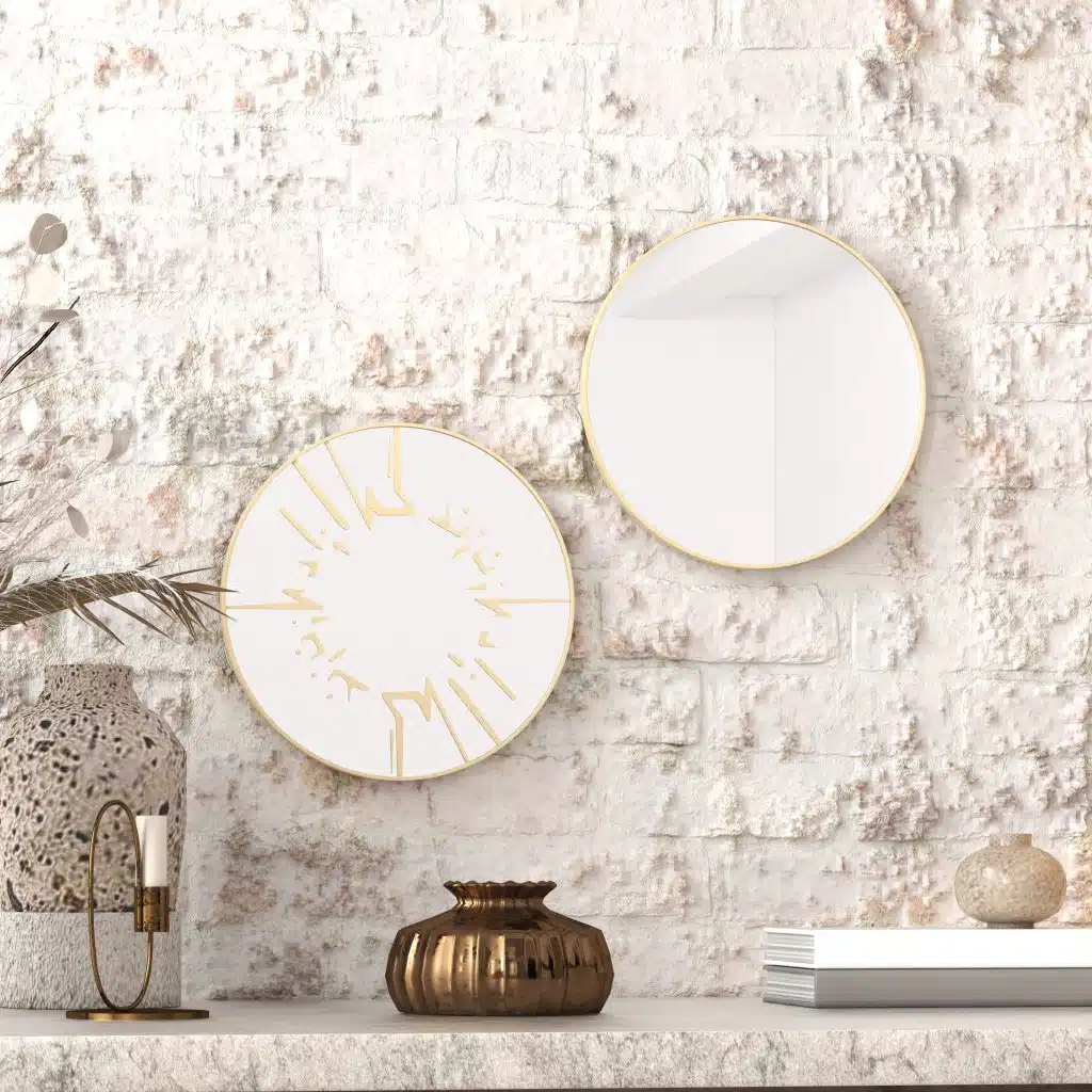 Small round wall mirror with an etched Persian calligraphy design featuring the words 'Women, Life, Freedom,' framed in a gold and black color scheme, hanging on a wall.