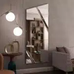 Full-length angled wall mirror with beveled diagonal lines and frameless design, available with black, gold, or silver wood backing.