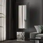 Free-standing full-length mirror with a beveled-edge glass panel, supported by a square cube base adorned with 3D prism-shaped mirrored artwork, perfect for contemporary interiors.
