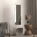 Free-standing full-length mirror with a beveled-edge glass panel, supported by a square cube base adorned with 3D prism-shaped mirrored artwork, perfect for contemporary interiors.