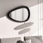 Sculptural organic wall mirror with matt black painted frame