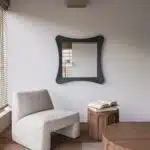 Handmade sculptural wall mirror in matt black paint